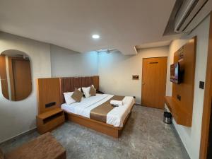 a bedroom with a bed and a television in it at Hotel Sun Lake in Ahmedabad