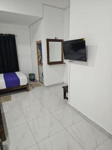 a bedroom with a bed and a flat screen tv at Nil Manel Tourist in Anuradhapura