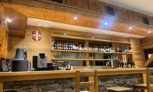 a bar with a bunch of bottles of alcohol at Chalet des Evettes in Flumet