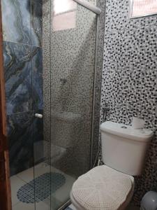 a bathroom with a toilet and a glass shower at Casa Nas Montanhas Capixabas in Domingos Martins +5 photos
