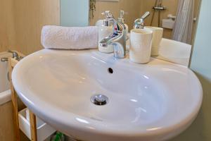 a bathroom sink with cups and toothbrushes on it at Owlswood Lodge in Orkney +69 photos