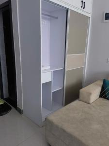 a white closet with a couch and a chair at Pride homes in Marimbeti