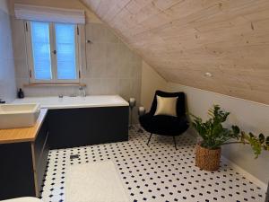 a bathroom with a sink and a black chair at Arabella in Rakvere