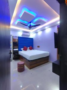 a bedroom with a bed and a ceiling with a blue light at Hotel Midnight in Muzaffarpur