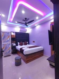 a bedroom with a large bed with a purple lighting at Hotel Midnight in Muzaffarpur