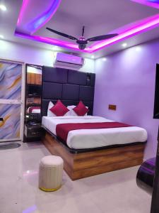 a bedroom with a large bed with purple lights at Hotel Midnight in Muzaffarpur