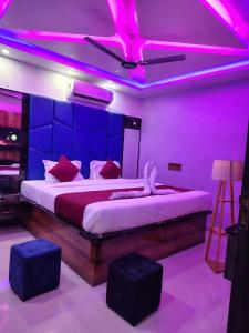 a bedroom with a large bed with purple lights at Hotel Midnight in Muzaffarpur