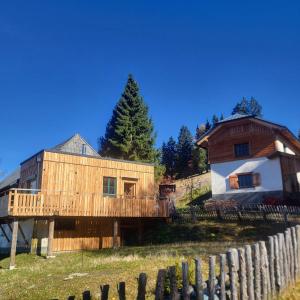 a house with a wooden fence next to a building at Sonnreichalm in Glein +6 photos