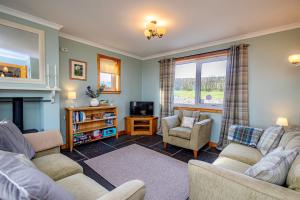 a living room with two couches and a tv at Owlswood Lodge in Orkney