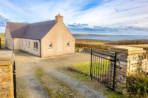 a small house with a gate in front of it at Owlswood Lodge in Orkney