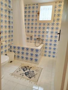 a bathroom with blue and white tiled walls and a tub at Almond trees house in Órmos Aiyialís