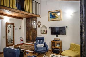 a living room with a tv and a chair at Al Castello di Leprignano in Capena