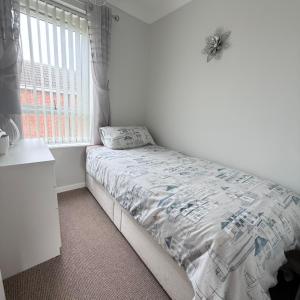 a white bedroom with a bed and a window at 30 Waterside in Corton +15 photos