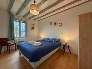 a bedroom with a blue bed with towels on it at Le Domaine de l'Ormurion in Sourdun +60 photos