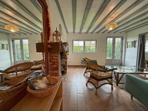 a living room with wicker chairs and a table at Le Domaine de l'Ormurion in Sourdun