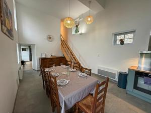 a dining room with a table and chairs and a staircase at Le Domaine de l'Ormurion in Sourdun