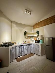 a kitchen with white table cloths on the counters at Fika Siargao - Cozy Island Home in General Luna in General Luna +6 photos