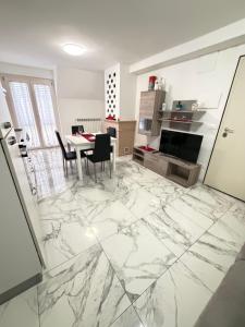 a kitchen with a marble floor with a table and chairs at Sun Beach in San Benedetto del Tronto