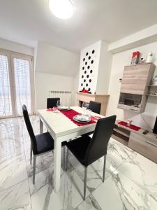 a white kitchen with a white table and chairs at Sun Beach in San Benedetto del Tronto