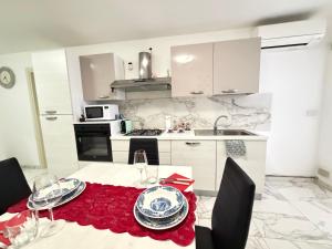 a white kitchen with a table with a red table cloth at Sun Beach in San Benedetto del Tronto +27 photos