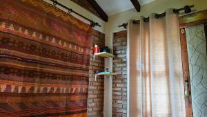 a room with a curtain and a brick wall at Cabaña Renacer in Samaipata +65 photos
