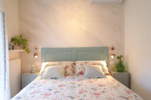 a bedroom with a bed with a floral bedspread and two pillows at Lo splendore dei Sassi in Matera