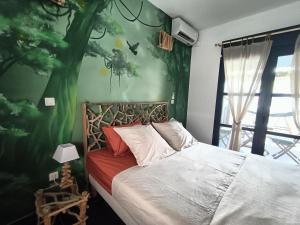 a bedroom with a bed with a green wall at La Cabane du lagon atypique et accès à la plage in La Saline les Bains