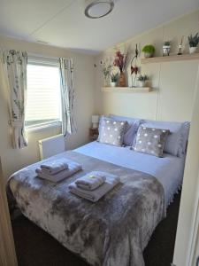 a bedroom with a large bed with towels on it at Seaside Caravan Home in Reighton +27 photos