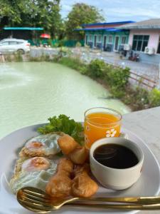 a plate of food and a cup of coffee on a table at สมหวัง โฮมสเตย์ in Ban Khuan Suan