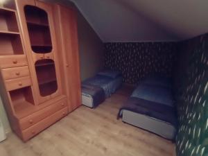 a small room with a bed and a cabinet at Chmurka in Bęczków