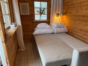 a small room with a bed in a wooden cabin at Skogsnära boende i Ludvigsborg in Ludvigsborg