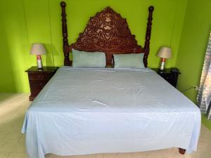 a bedroom with a large bed with green walls at Reggae Moon Guesthouse in Falmouth