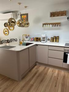 a kitchen with white counters and white cabinets at Chiswick Garden Studio with Outdoor Pool and Boutique Finish in London +22 photos