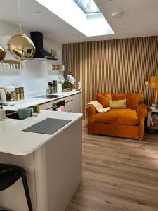 a kitchen with an orange couch in a living room at Chiswick Garden Studio with Outdoor Pool and Boutique Finish in London