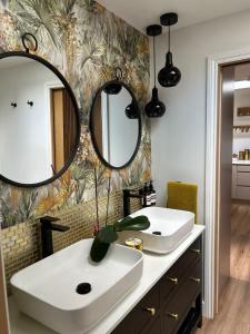 a bathroom with a white sink and two mirrors at Chiswick Garden Studio with Outdoor Pool and Boutique Finish in London