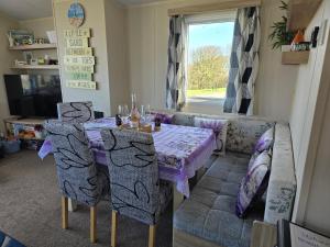 a living room with a table and a couch at Seaside Caravan Home in Reighton