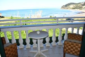 un tavolo su un balcone con vista sull'oceano di SeasoundStudios ad Agios Stefanos
