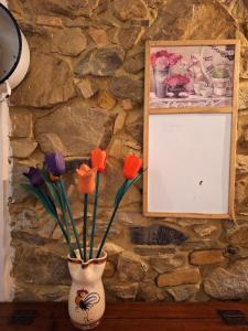 a vase with flowers in it next to a stone wall at Giagio & Aceto in Larciano +16 photos