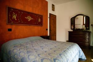 a bedroom with a bed and a dresser and a mirror at Giagio & Aceto in Larciano