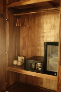 a microwave sitting on a shelf in a kitchen at Sabay Koh Rong in Koh Rong Island +37 photos