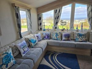 a large couch in a room with windows at Seaside Caravan Home in Reighton