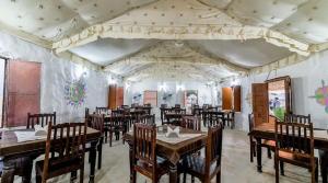 a restaurant with tables and chairs in a room at Best desert camp in jaisalmer The Velvet Dunes in Sām