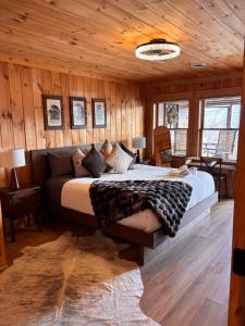 a bedroom with a bed in a room with wooden walls at Classy Bear Cabin - Summit Views of Ober Mountain, Hot Tub, 3 King Beds, 2 Mi to Downtown in Gatlinburg