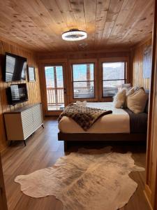 a bedroom with a large bed in a wooden room at Classy Bear Cabin - Summit Views of Ober Mountain, Hot Tub, 3 King Beds, 2 Mi to Downtown in Gatlinburg