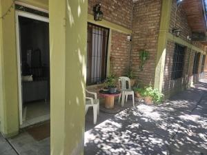 a patio with two white chairs and a brick building at Casita de Frasca in San José de Jáchal +1 photo