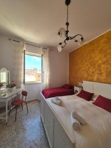 a bedroom with a bed and a desk and a window at Due Passi Dal Centro in Marsala