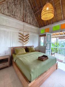 a bedroom with a large green bed with a ceiling at Purwa Ijen in Banyuwangi