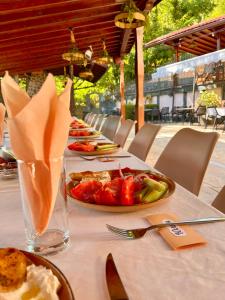 a table with plates of food and a bowl of fruit at Hotel Restaurant Vodenitsata in Berkovitsa +21 photos