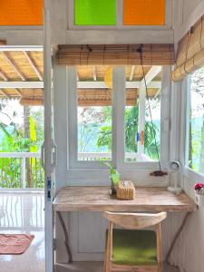 a table in a tiny house with a window at Purwa Ijen in Banyuwangi