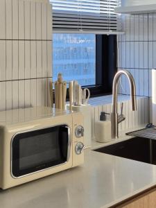 a microwave sitting on top of a kitchen counter at 로프트부산 loft busan in Samgong